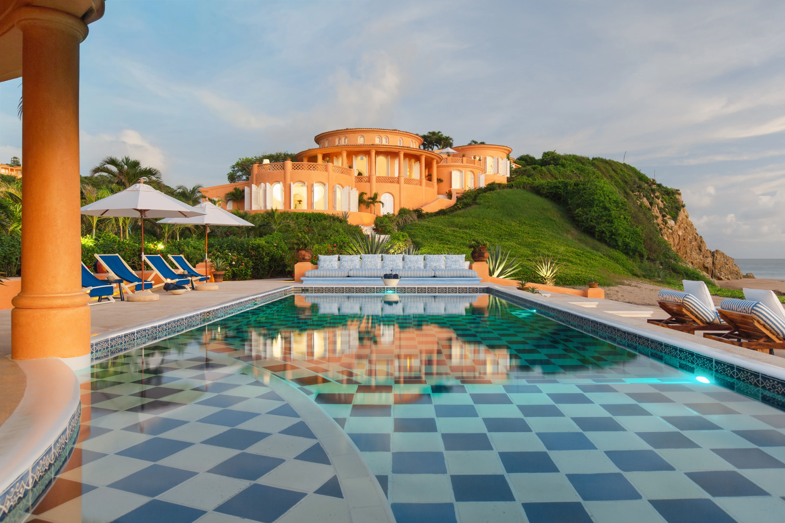 Group of friends by a private villa pool at golden hour